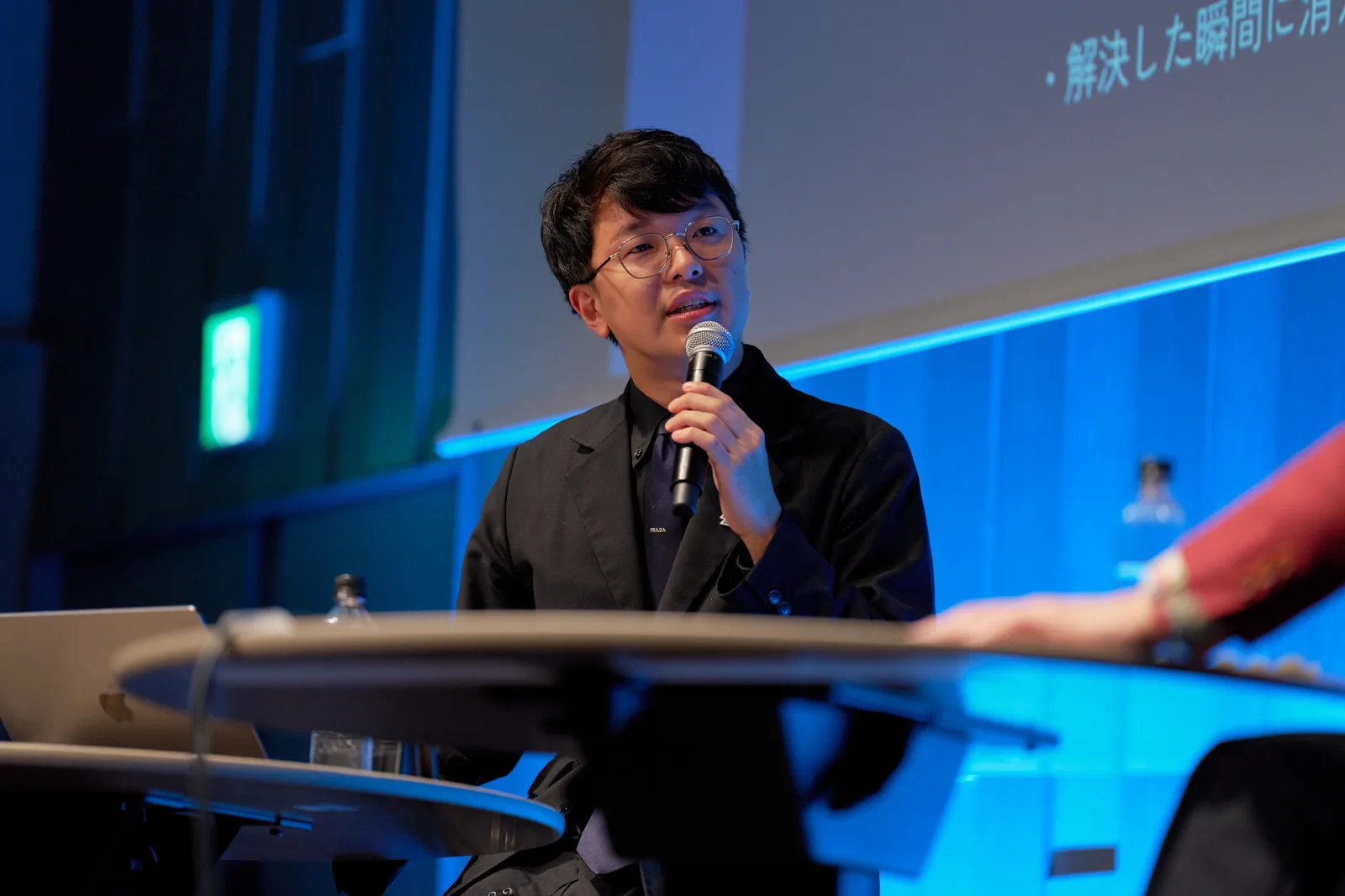 着席して相手の話を受けながら語る小澤健祐